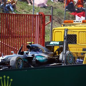Rosbergs auto wordt op een truck naar de pits gebracht.