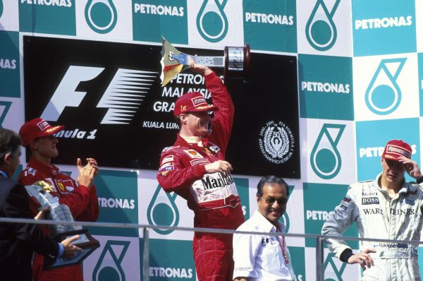 Op het podium wist Eddie Irvine nog niet dat hem een diskwalificatie boven het hoofd hing - die later weer zou worden ingetrokken