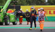 Sergio Pérez loopt weg na zijn crash, terwijl zijn bolide wordt weggetakeld.